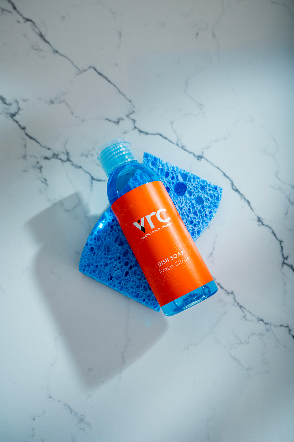 VRC's vacation rental amenities, custom branded mini bottle of dish soap on a blue sponge on the kitchen counter at 