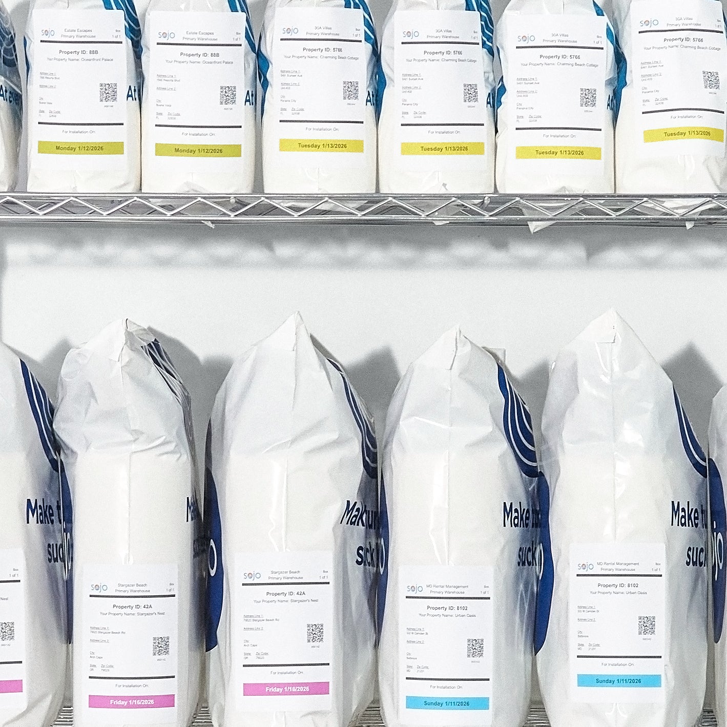 Sojo labeled laundry bags with installation dates organized on metal shelf