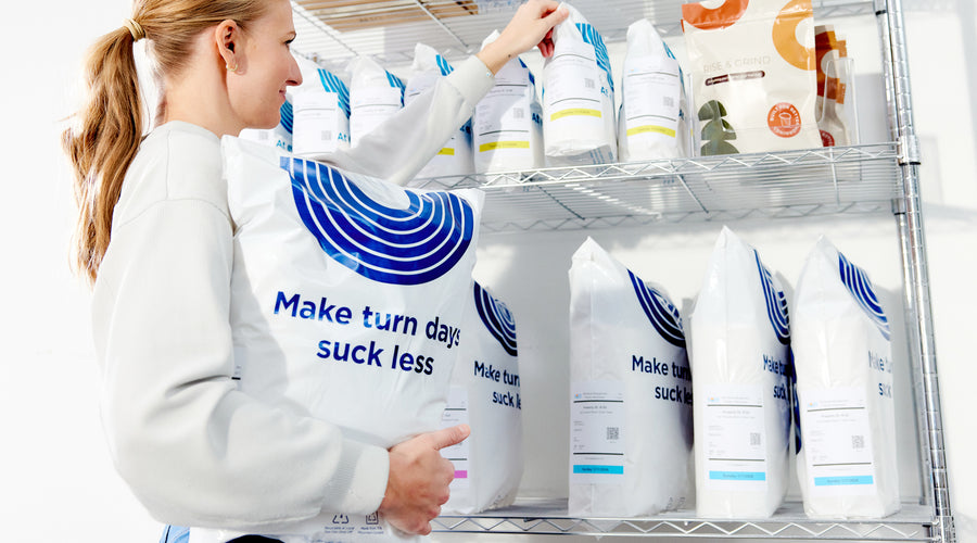 Woman organizing SOJO VisionKit bags on metal shelving in a clean storage room