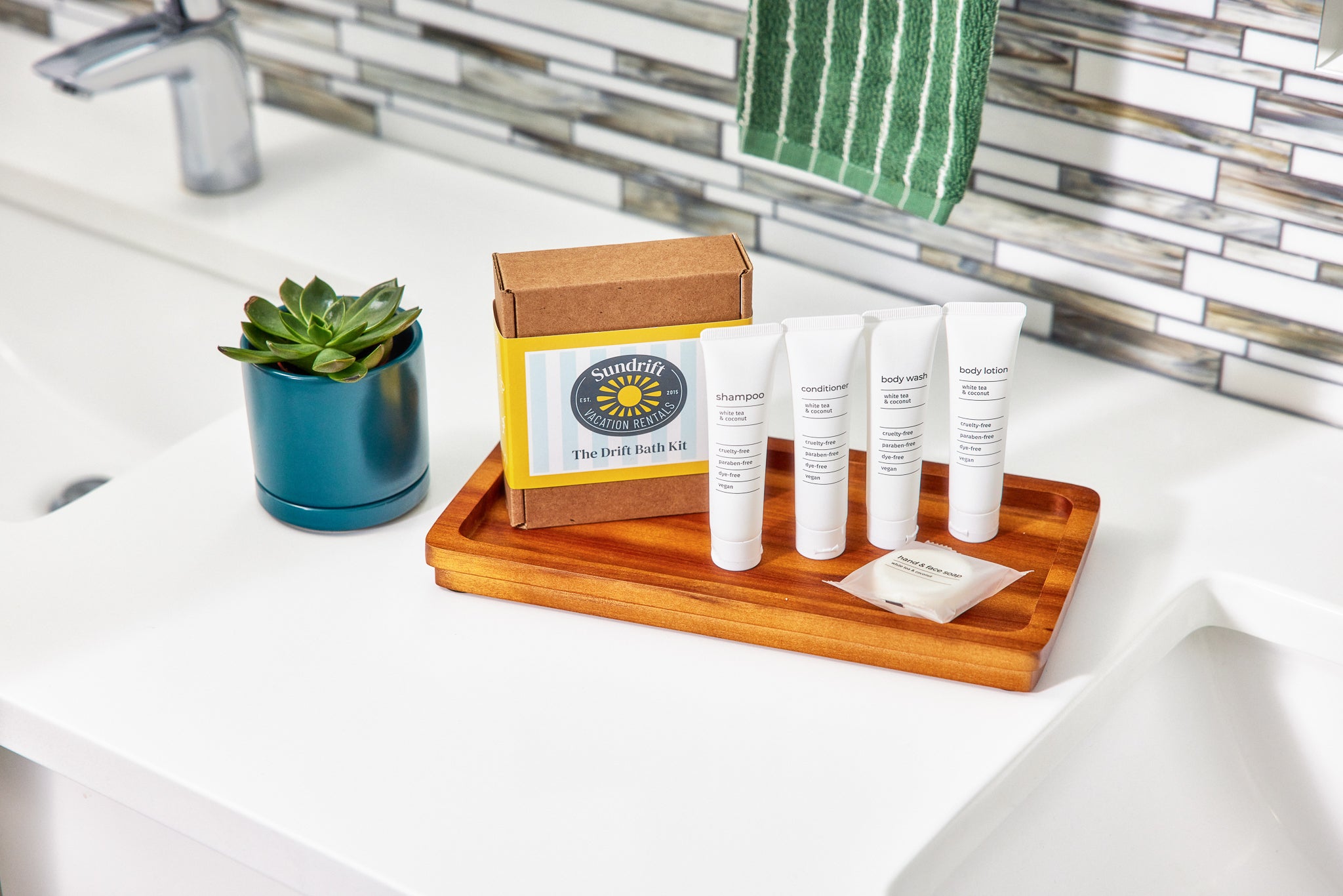 Drift Bath Kit with toiletries on wooden tray by bathroom sink and potted succulent.