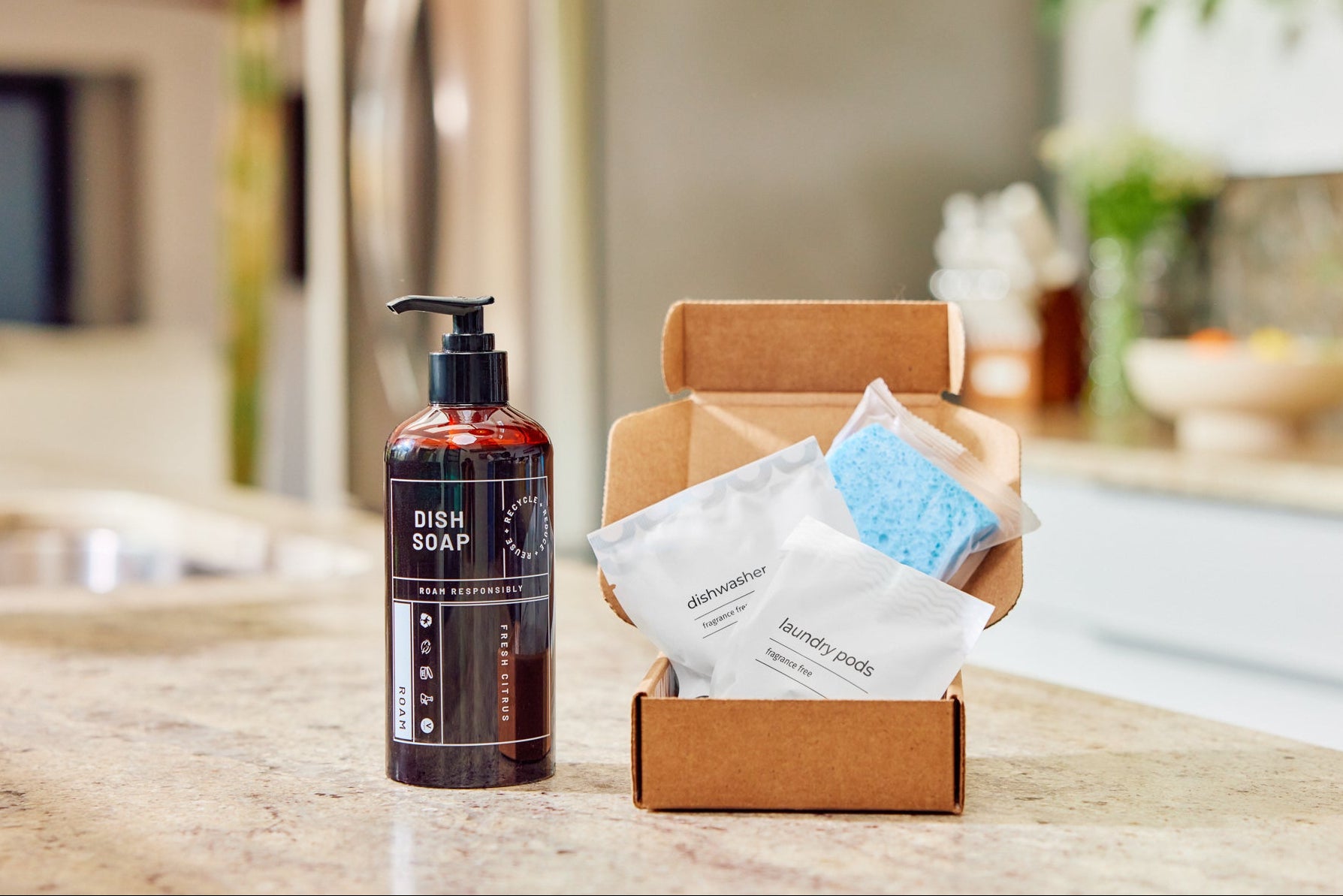 Bottle of fresh citrus dish soap next to a box of laundry pods and dishwasher tabs.