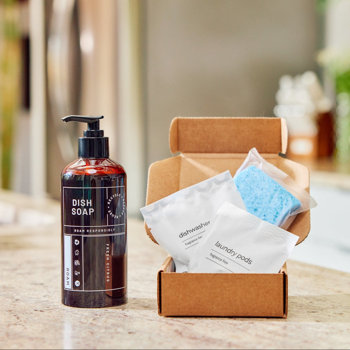 Box of kitchen amenity products and a dish soap bottle on a kitchen counter