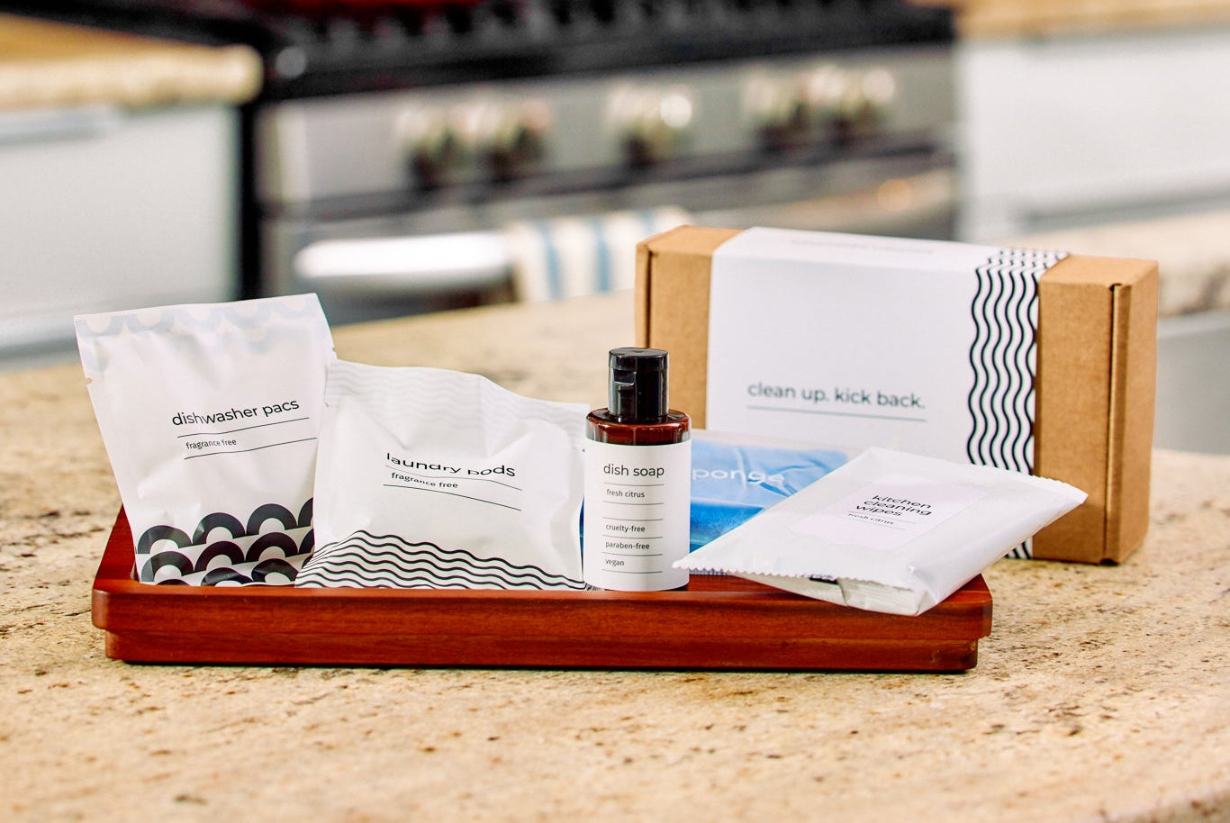 Eco-friendly cleaning kit with dish soap, dishwasher pacs, laundry pods on kitchen counter