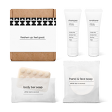 Bathroom essentials kit with shampoo, conditioner, body bar soap, and hand and face soap in a bag.