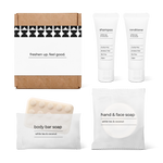 Bathroom essentials kit with shampoo, conditioner, body bar soap, and hand and face soap in a bag.