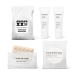 Bathroom essentials kit with shampoo, conditioner, body bar soap, and hand and face soap in a bag.