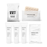 Bathroom amenities kit including shampoo, conditioner, body lotion, body bar soap, and makeup wipe in a bag.