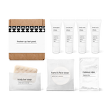 Bathroom amenities kit including shampoo, conditioner, body wash, body lotion, body bar soap, hand and face soap, and makeup wipe in a box.