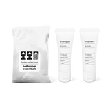 Bathroom amenities kit featuring shampoo and body wash in travel-size bottles in a bag.