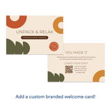 Branded welcome card reading "Unpack & Relax" with message about a complimentary stay bundle and a QR code for booking